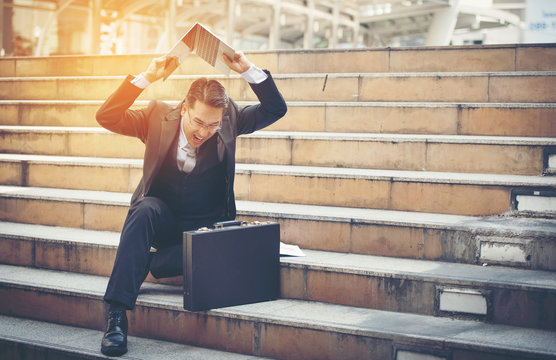 Businessman Stressed With Notebook On Stairs