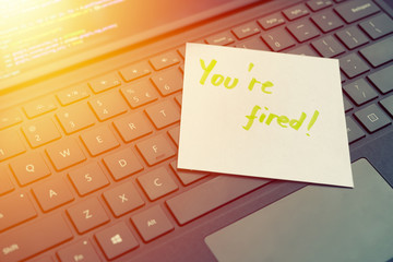 You're fired message concept written post it on laptop keyboard
