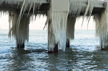 The sea is frozen. Pier in the ice. Sea coast in the ice in the winter. The frozen Baltic Sea.