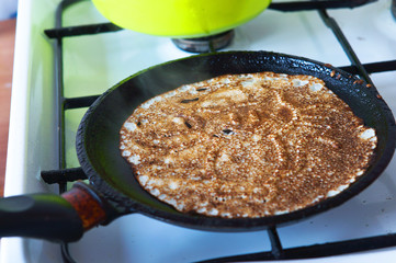 The pancakes in the pan, carnival. Bake delicious pancakes at home.