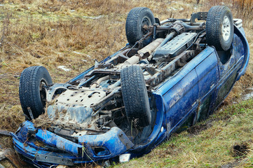 Traffic accident. A blue car overturned. The car lies in a roadside ditch.
