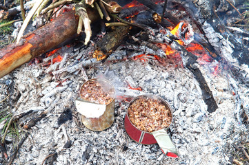 Reheat the porridge in a tin at the bonfire on the camping trip.