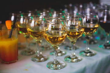 Beautiful row line of different colored alcohol cocktails on a party,  on decorated catering bouquet table
