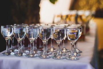 Beautiful row line of different colored alcohol cocktails on a party,  on decorated catering bouquet table
