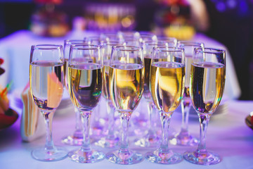 Beautiful row line of different colored alcohol cocktails on a party,  on decorated catering bouquet table
