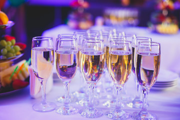 Beautiful row line of different colored alcohol cocktails on a party,  on decorated catering bouquet table
