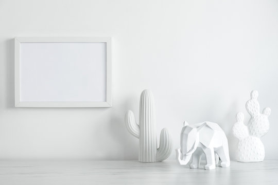 Creative white interior with copy space , cacti and elephant figures. White concept of mock up photo frame. 