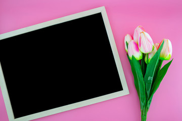 Beautiful of yellow tulip flower and chalkboard, blackboard with flat lay on the pink background, top view, copy space, mother day and holiday concept.