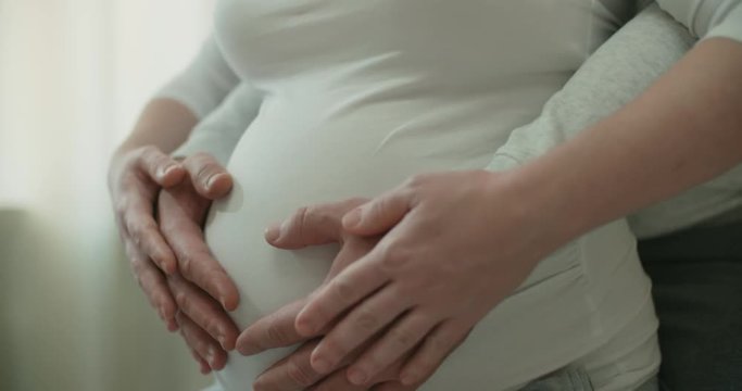 Mom and dad hands on pregnant tummy. Pregnant couple caressing pregnant belly. Expectant mother care. Maternity concept. Pregnancy. Happy family