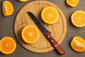 Sliced Orange with Knife on Wooden Cutting Board. Organic Fruits on Dark Background. Healthy Concept. Top View.