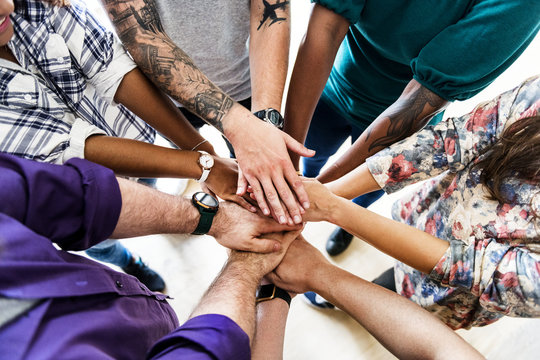 Group of diverse people joined hands together teamwork