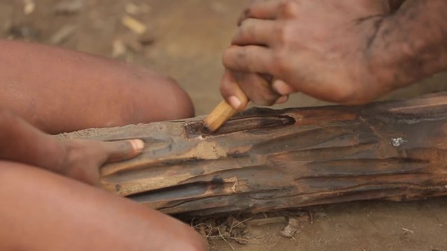 Adult and child use a traditional hand drill to get a fire to Vanuatu. The tribe fires with sticks. Tanna Island in Vanuatu. May 2016