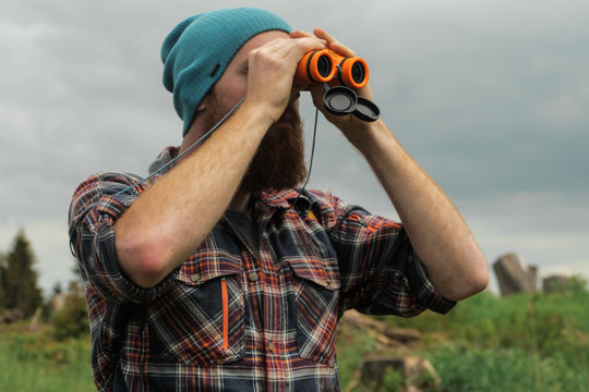 male hiker using binoculars outdoors