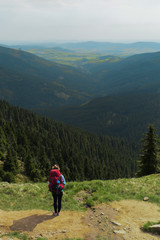 Fototapeta na wymiar female hiker walking on a trail on highlands, jeseniky mountains, czech republic