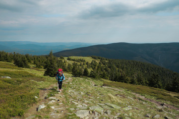 female hiker walking on a trail on highlands, jeseniky mountains, czech republic