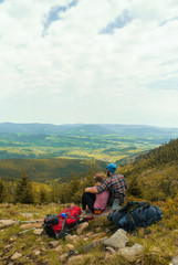 hiking couple, two hikers sitting on a hill and admiring view on a open landscape, jeseniky mountains, czech republic