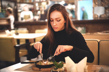 Young elegant brunette woman enjoy eating meal in the restaurant
