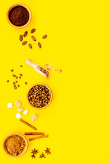 Ingredients for bakery and desserts. Cinnamon, cocoa, coffee, sugar, spices on yellow background top view space for text