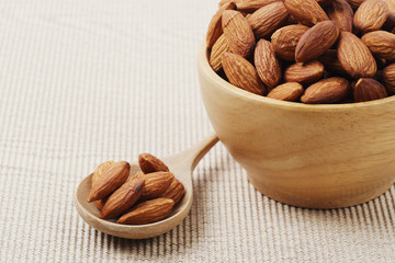 dry almonds nuts in a wooden spoon