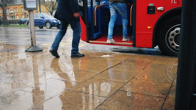 People getting on a bus. Rainy day.