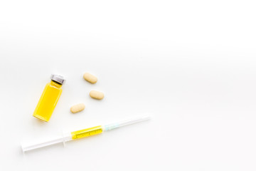 Medical therapy. Syringe, bottle with drug, pills on white background top view copy space