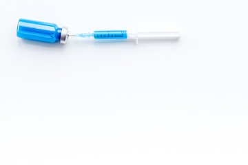 Syringe with colored drug. Injection concept on white background top view copy space