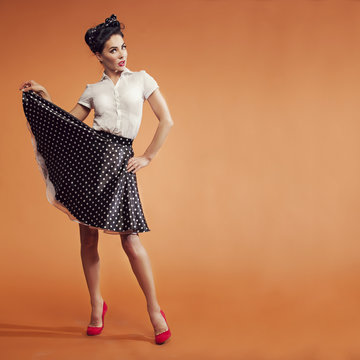 girl on orange background with the polka dot skirt