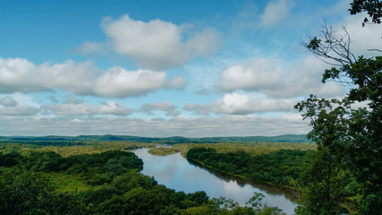 Landscape of river in forest and blue cloudy sky