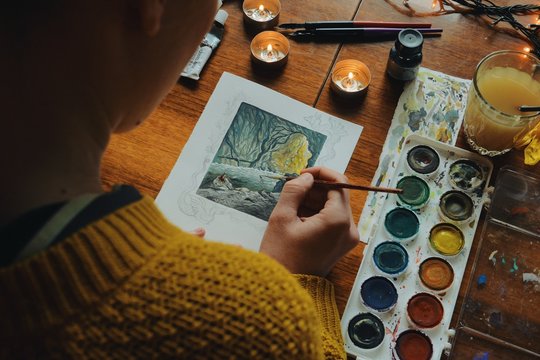 woman painter artist painting a picture of a fantasy cave with watercolour