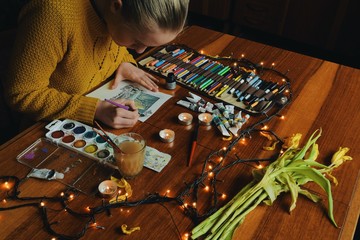 woman painter artist painting a picture of a fantasy cave with watercolour