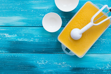 Homemade orange ice cream on a blue wooden background. Fruit frozen dessert