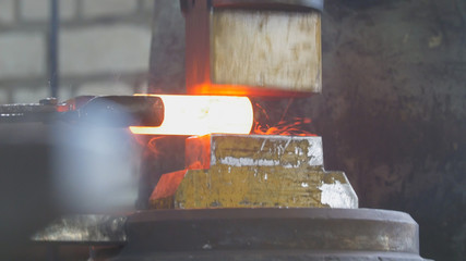 Blacksmith with hammer in forge creating steel knife