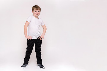 cute boy aged 6 years shows on a white background in different poses different emotions