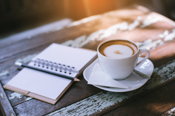 Notebook and coffee on wooden background