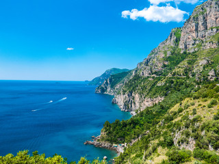 Infinite view of the Amalfi Coast with wild coastline, perfectly preserved environment, vertical rocky cliffs, luxuriant green forest and blue coves of the Mediterranean sea. - Amalfi, Naples, Italy