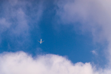 Fototapeta na wymiar view of plane from ground. travel concept. blue sky with white clouds