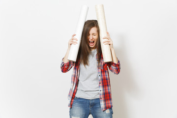 Young irritated woman in casual clothes holding wallpaper rolls near head and screaming isolated on...