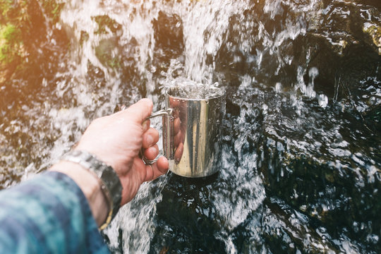 Hand Pouring Water In Cup Outdoor.