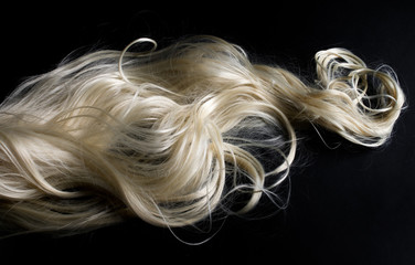 Long blond hair isolated on black background