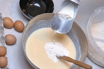 Kneading dough for pancakes. With flour and egg