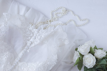 Preparing the bride for the wedding: dress, pearls, roses - wedding background
