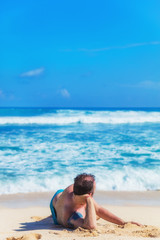 Man lying and enjoying on a sandy tropical beach.