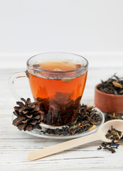 Cup of tea with tea leaves scattered.