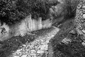 Monochrome photo. Narrow old stone street and yard in Milies village,Pelion mountain, Greece