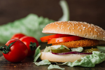 fresh tasty fishburger on wooden table