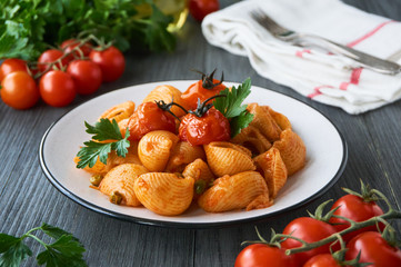 Pasta with green peas and baked cherry tomatoes on a plate       