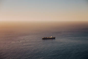 Oil tanker ship on calm ocean at sunset