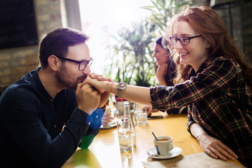 Handsome man flirting with cute woman in restaurant