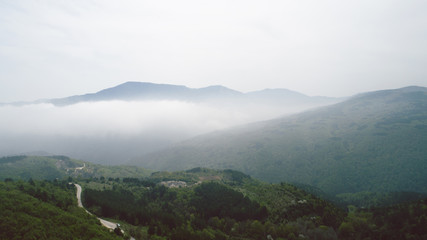 Aerial View With Mountain Road And Heavy Mist At The Background 