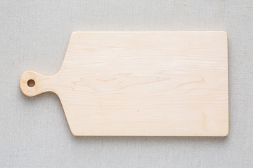 Maple handmade wood cutting board on the linen